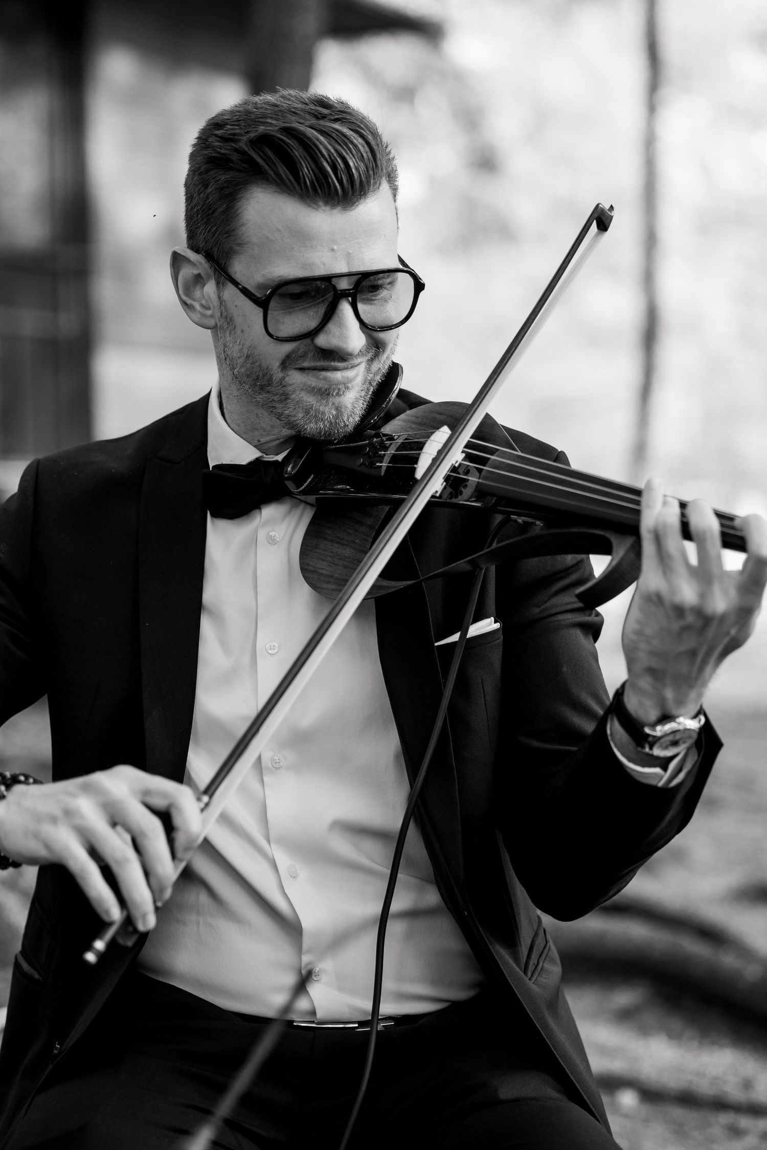 A musician in formal attire plays an electric violin during an elegant performance.