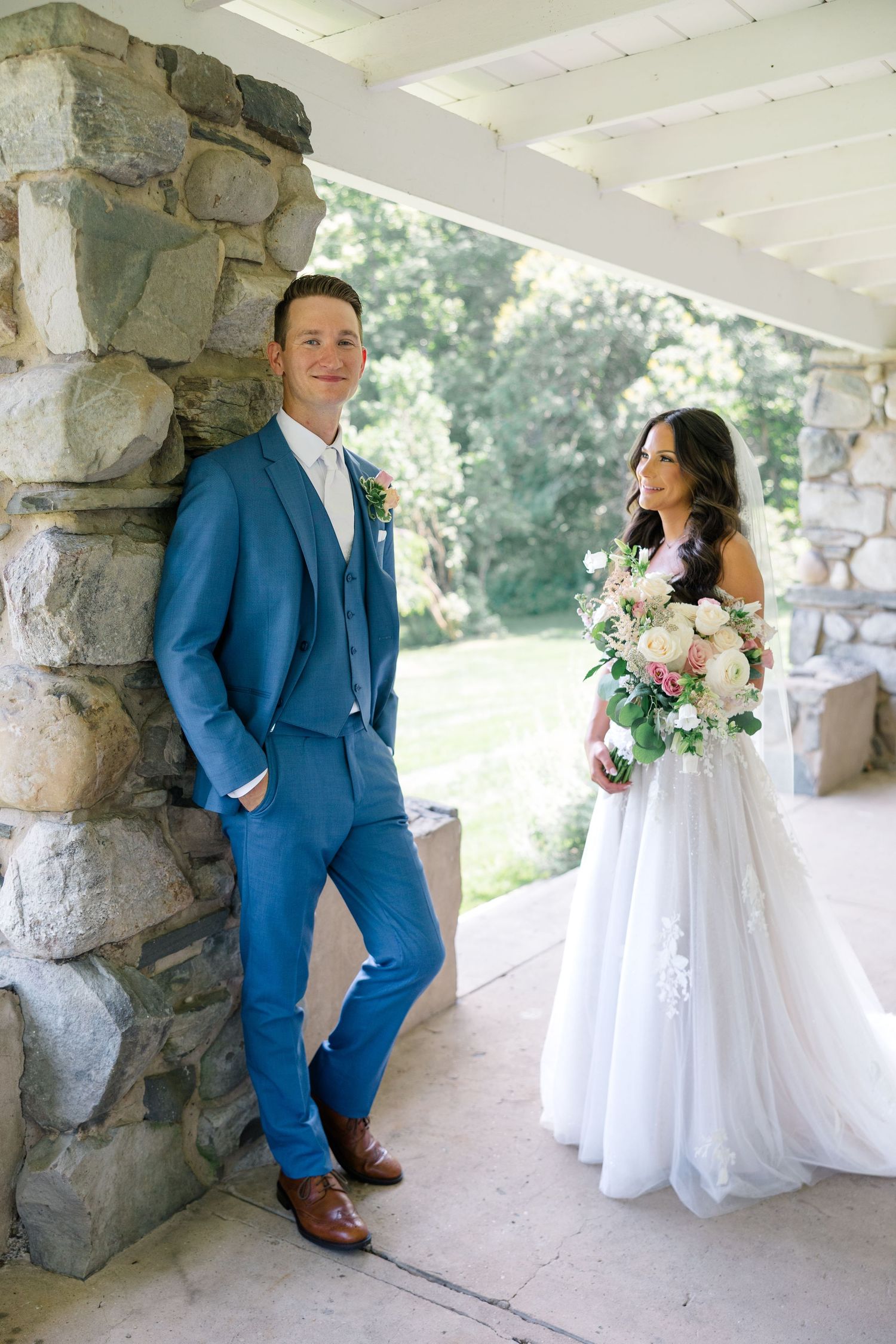 Wedding portraits under a stone colonnade with rustic architectural details and natural lighting.