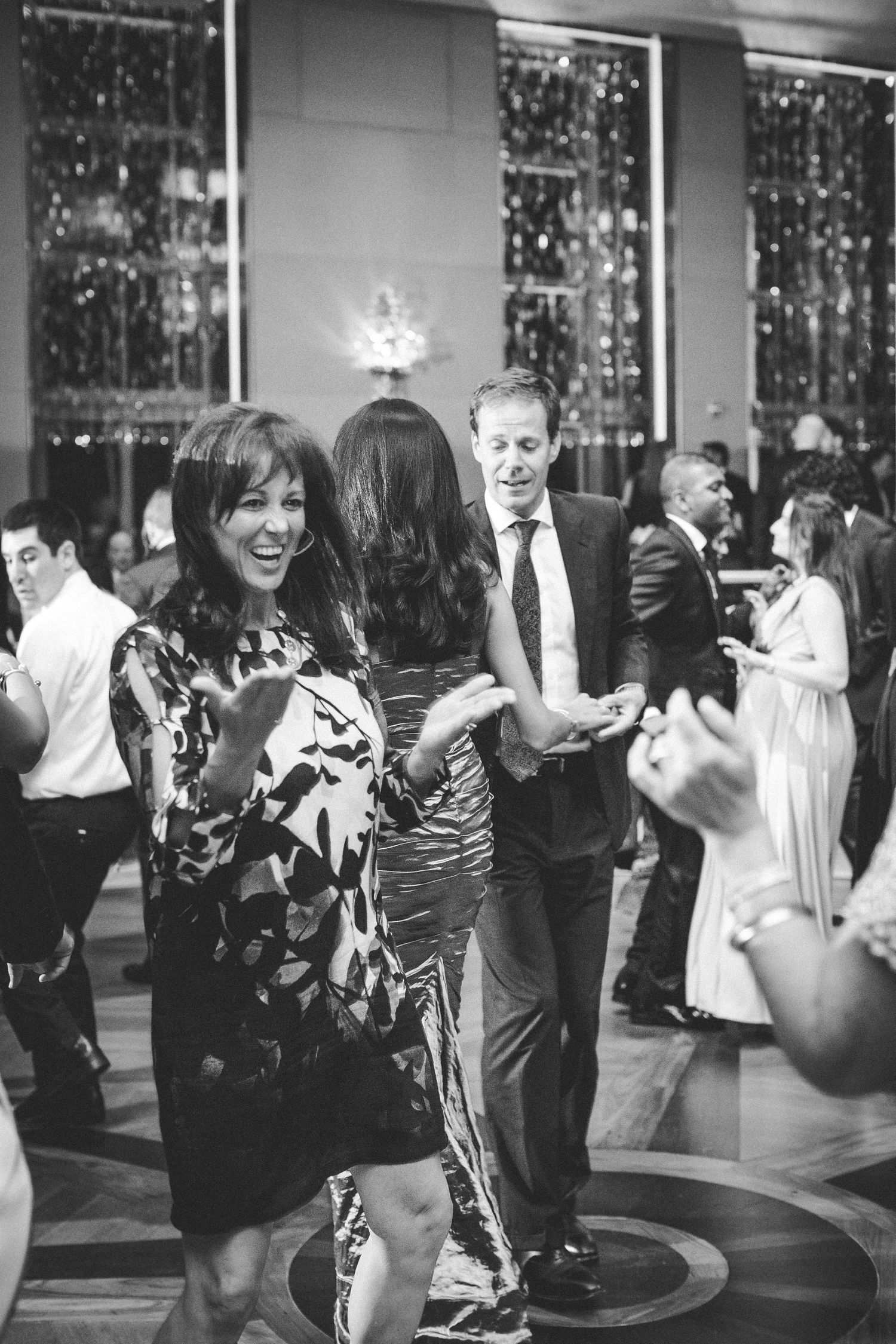 Black and white photograph of guests dancing and socializing at an elegant evening celebration.