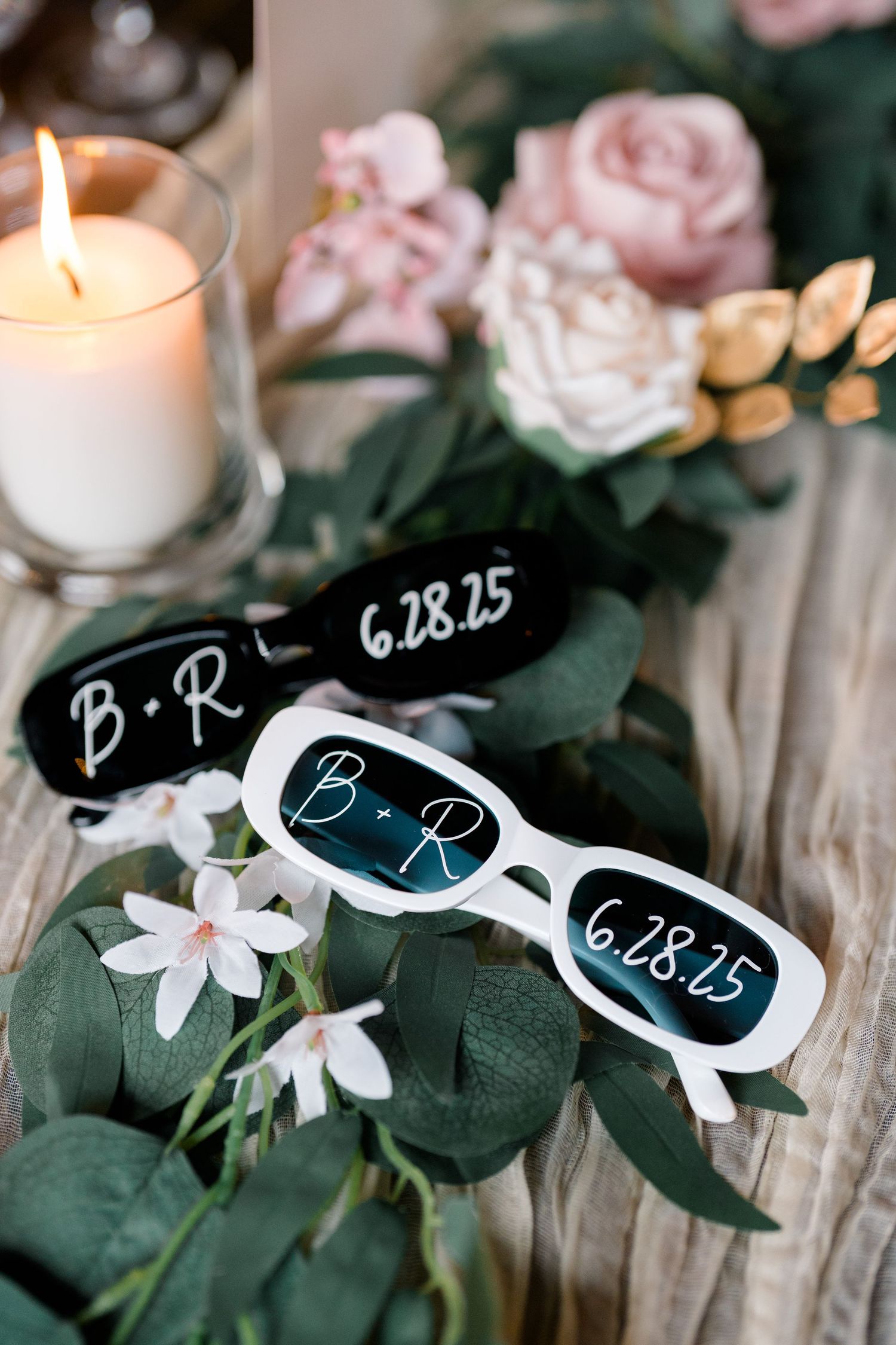 Wedding reception table details with personalized sunglasses favors and date markers.