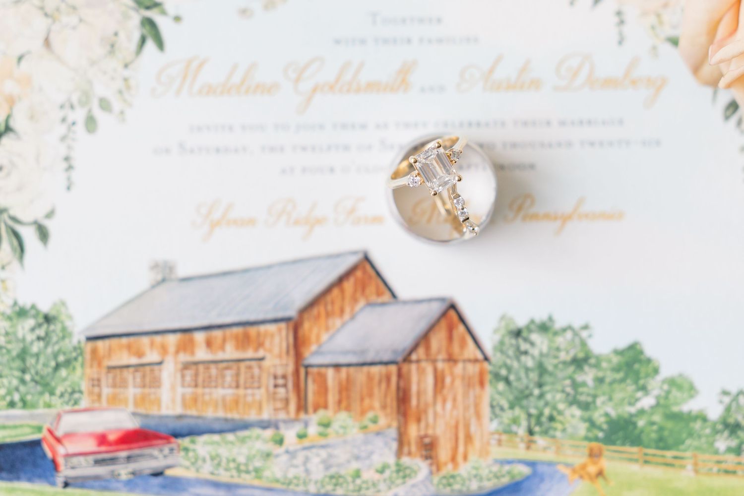 Wedding invitation for Madeline Goldsmith and Austin Danburg with illustrated barn venue and gold cross cufflinks.