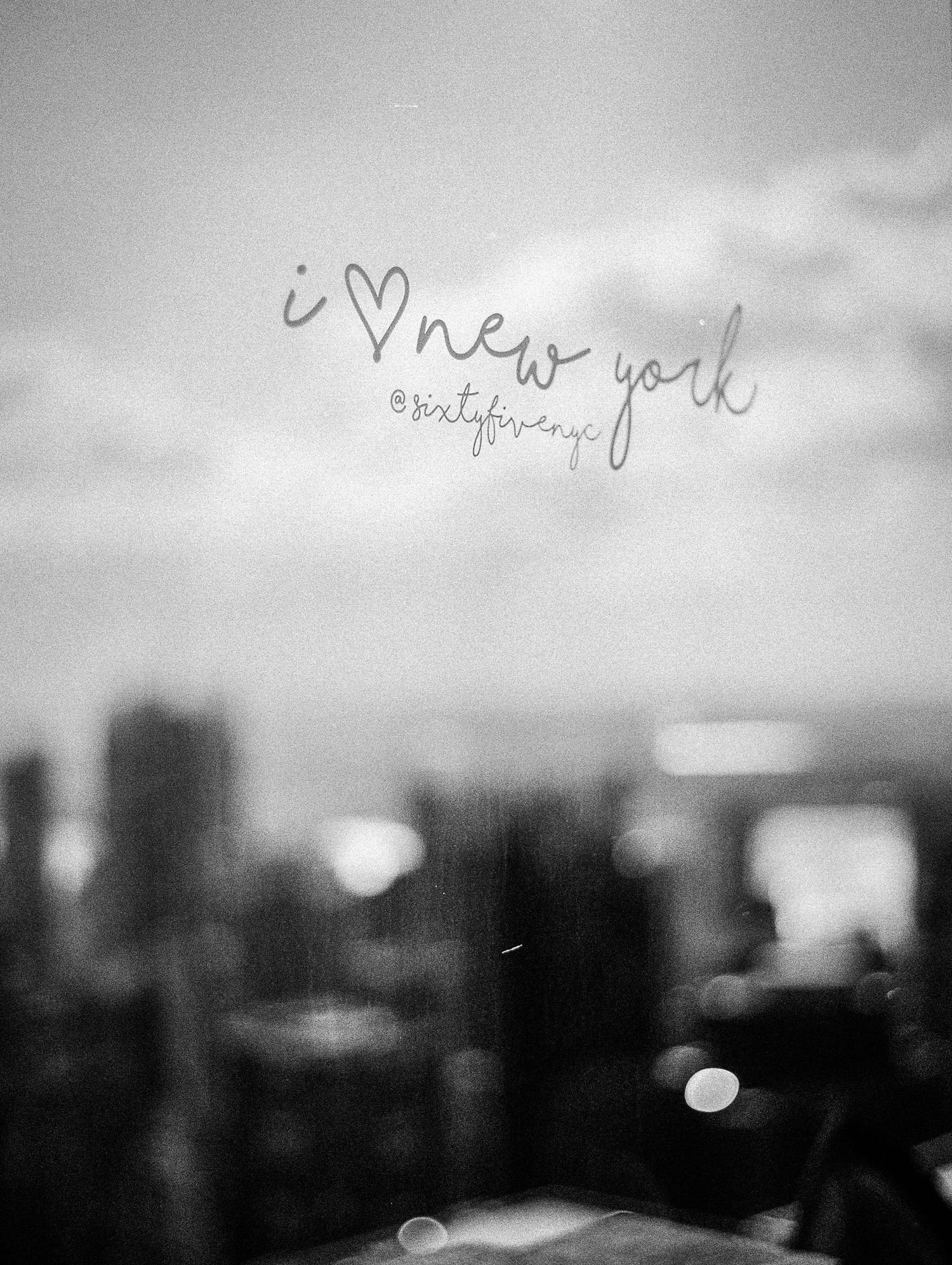 Black and white skyline of New York City with 'i heart new york' handwritten text overlay.