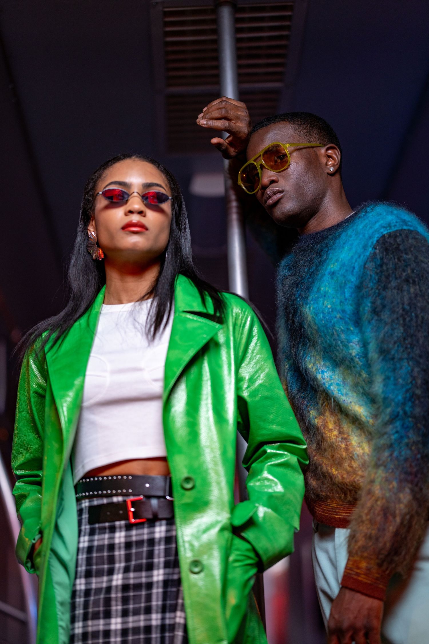Fashion model wearing bright green jacket and plaid skirt poses confidently.