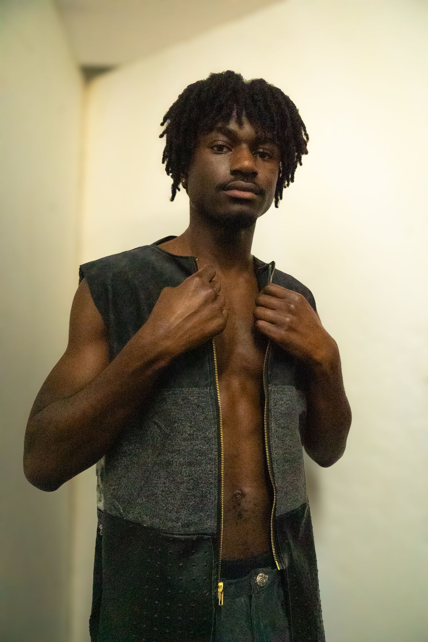 Person wearing dark vest poses in sequence showing different angles.
