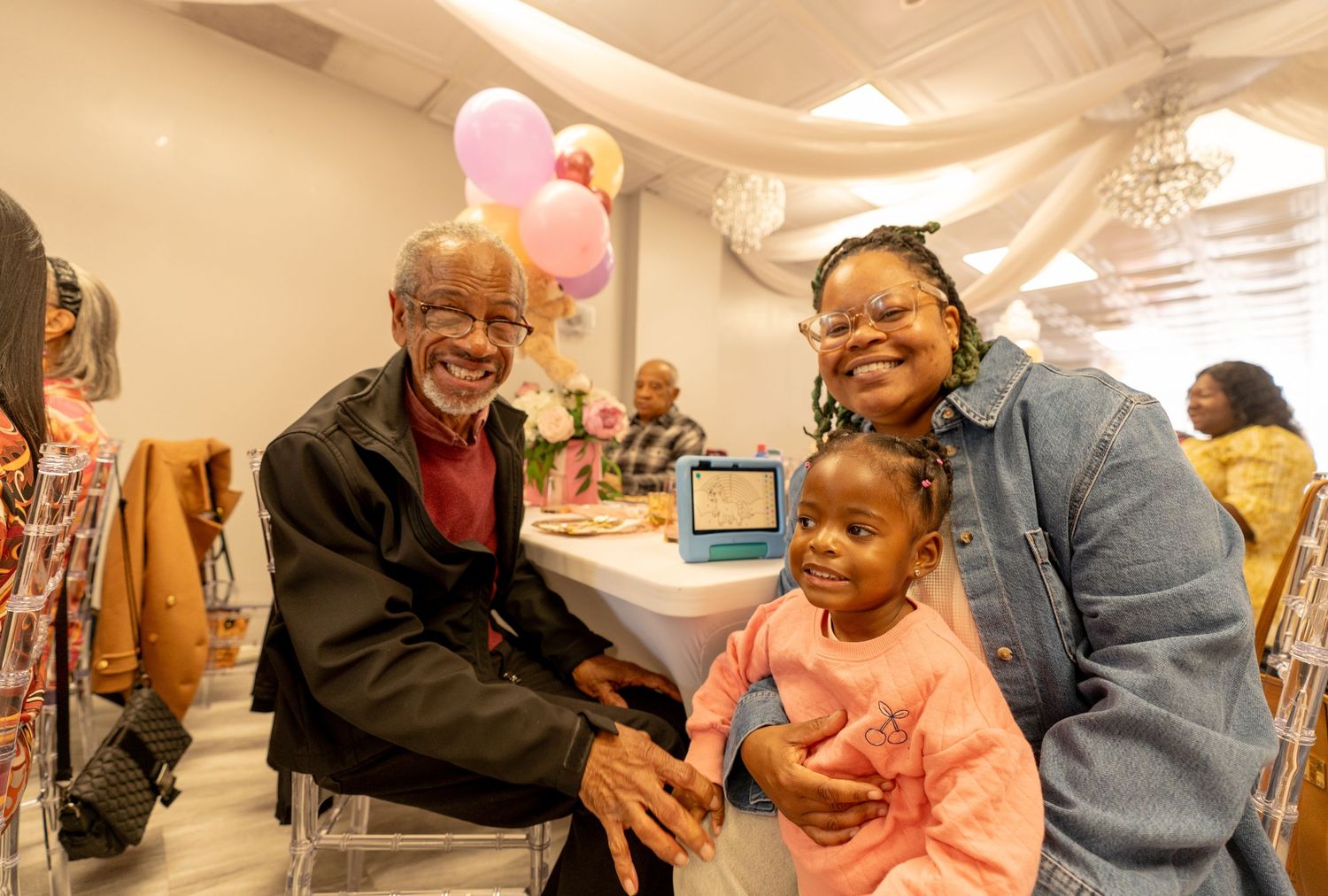 Family gathering with people interacting in a casual indoor setting.