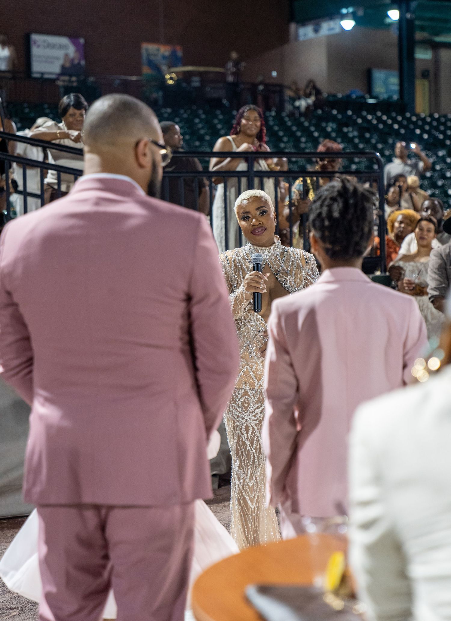 Performers in pink suits dancing at an event venue.