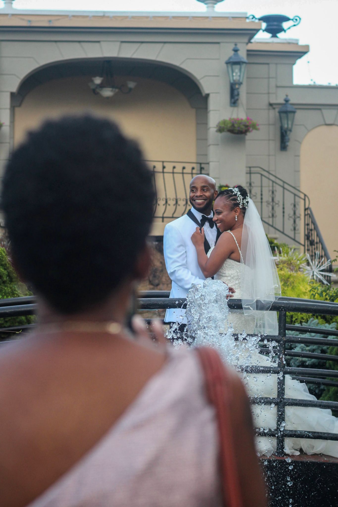 Couple celebrating with water splashing during their outdoor wedding photoshoot.