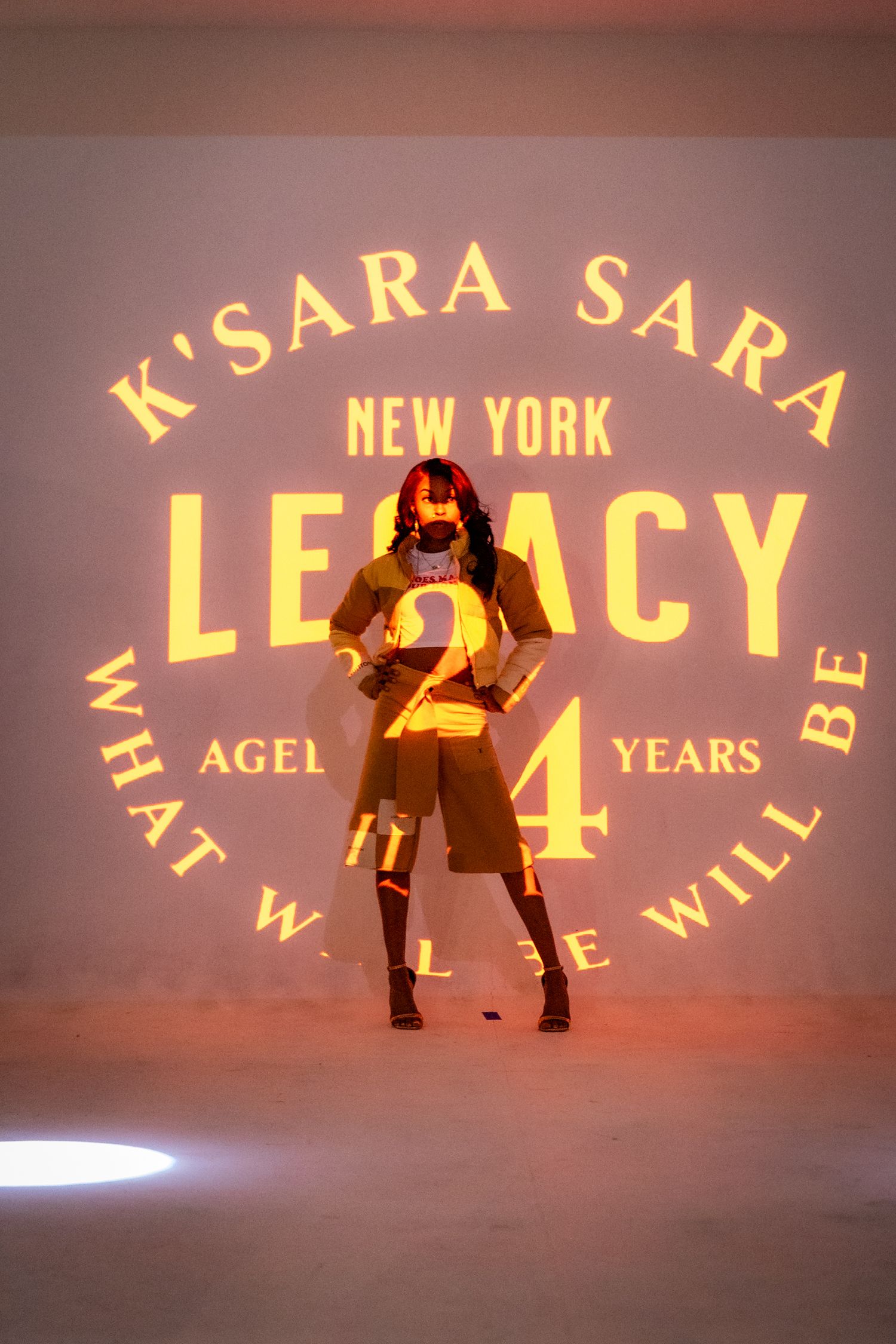 Yellow text projection displaying 'LEGACY' against a dark background.