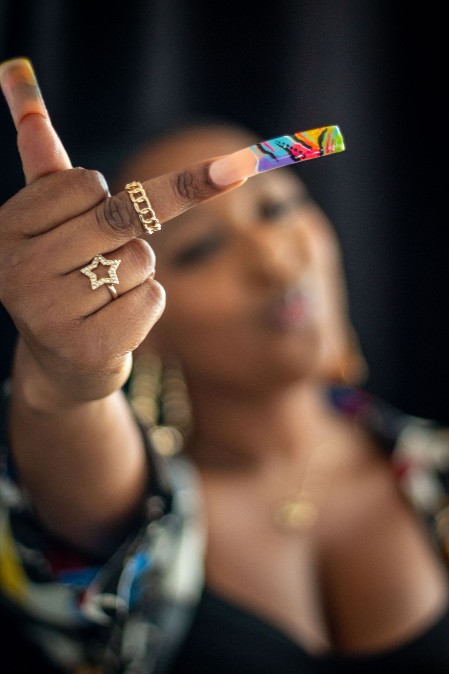 Close-up shots of hands displaying colorful rings against dark background.