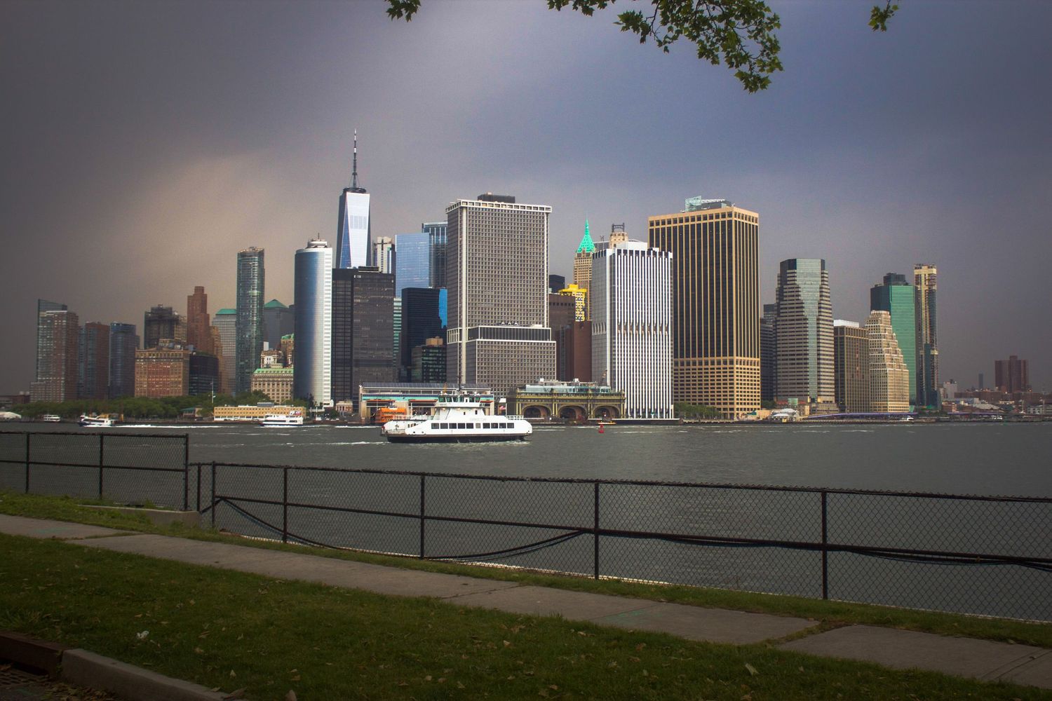 Panoramic view of the Manhattan skyline with ferry boat on a cloudy day.