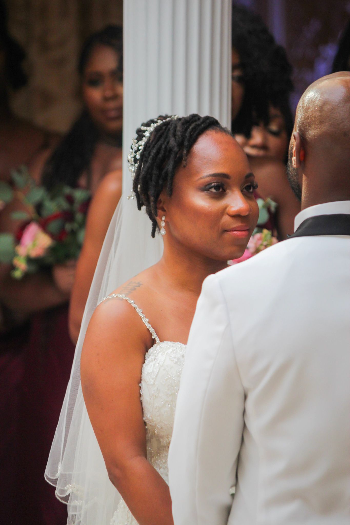 Elegant wedding ceremony with white columns and floral decorations.