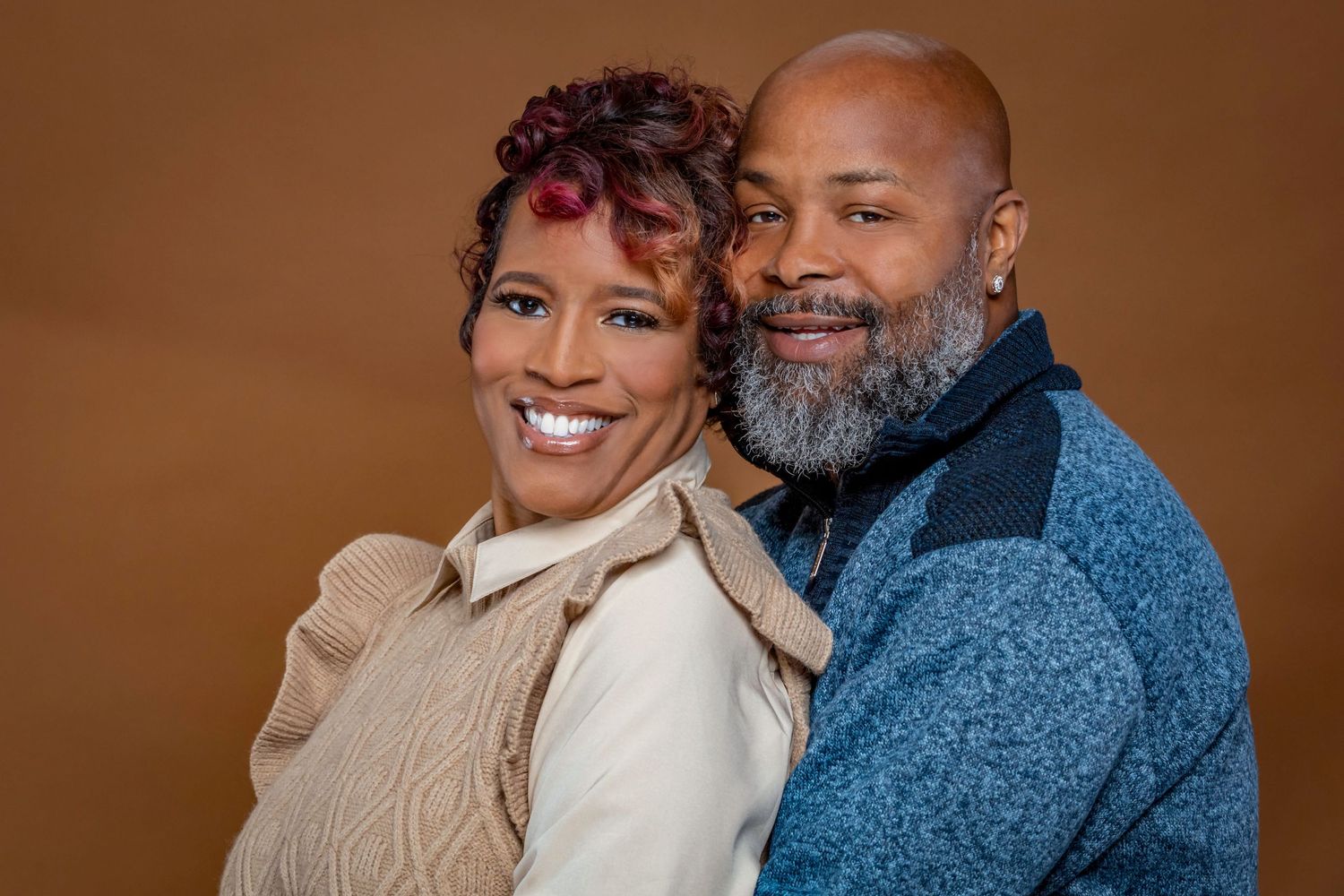 Intimate studio portrait of couple wearing cozy winter sweaters.