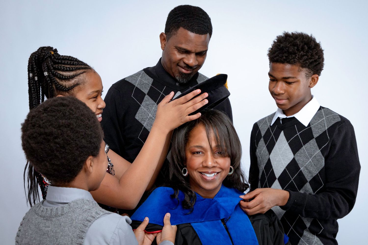 Family gathered around looking at mobile devices together.