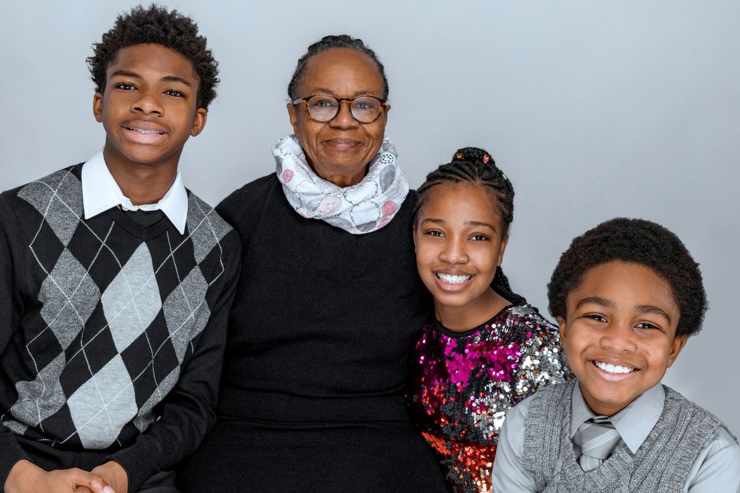 Multi-generational family portrait with coordinated argyle sweaters.