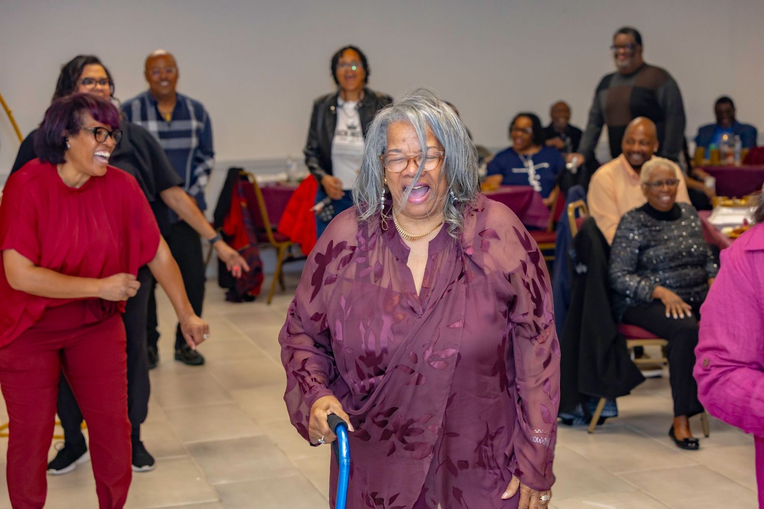 People enjoying a social gathering with dancing and movement in a community space.