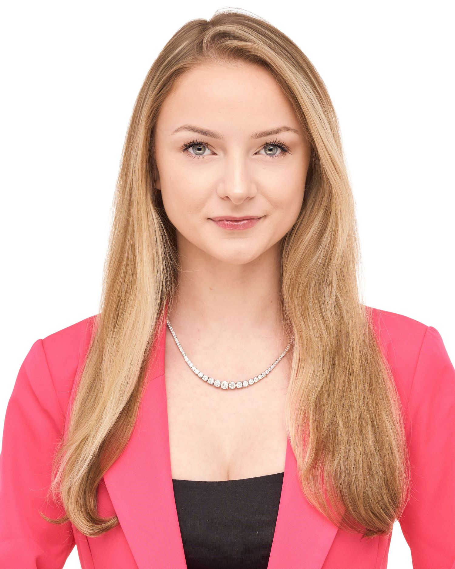 Professional headshot of a young woman with long blonde hair wearing a pink blazer and diamond necklace.