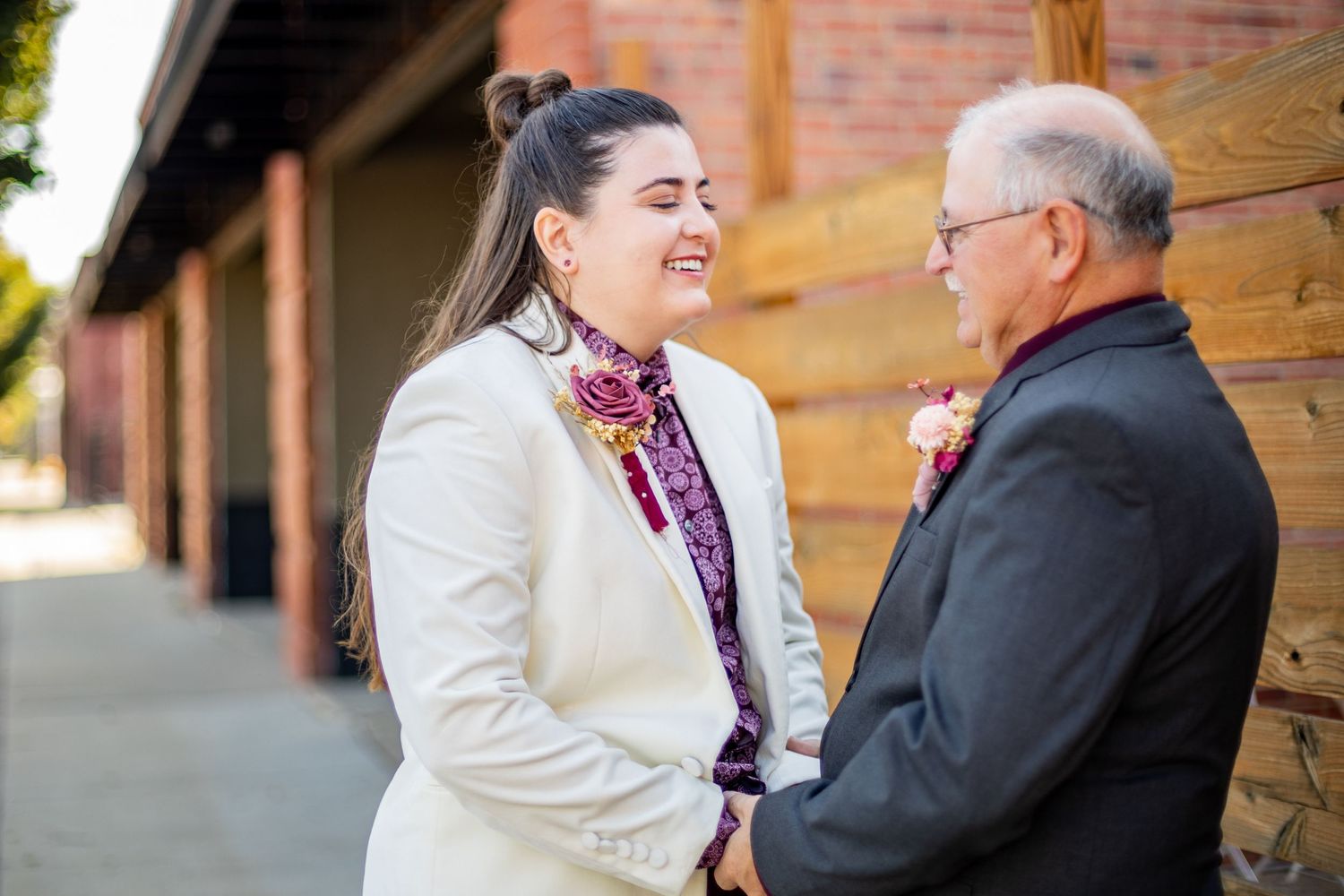 Heartwarming moment shared between two people against wooden wall backdrop.
