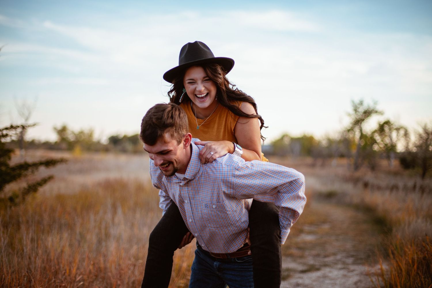 Playful piggyback ride in rural setting during autumn.