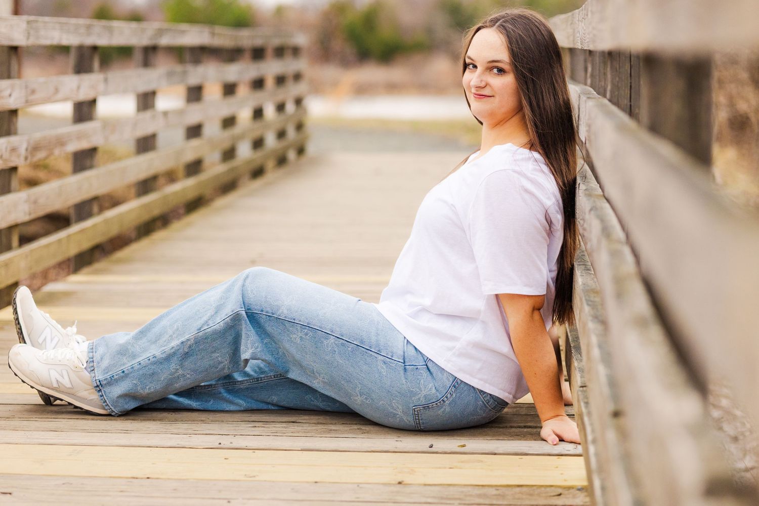 Casual portrait on wooden boardwalk with jeans and white t-shirt.