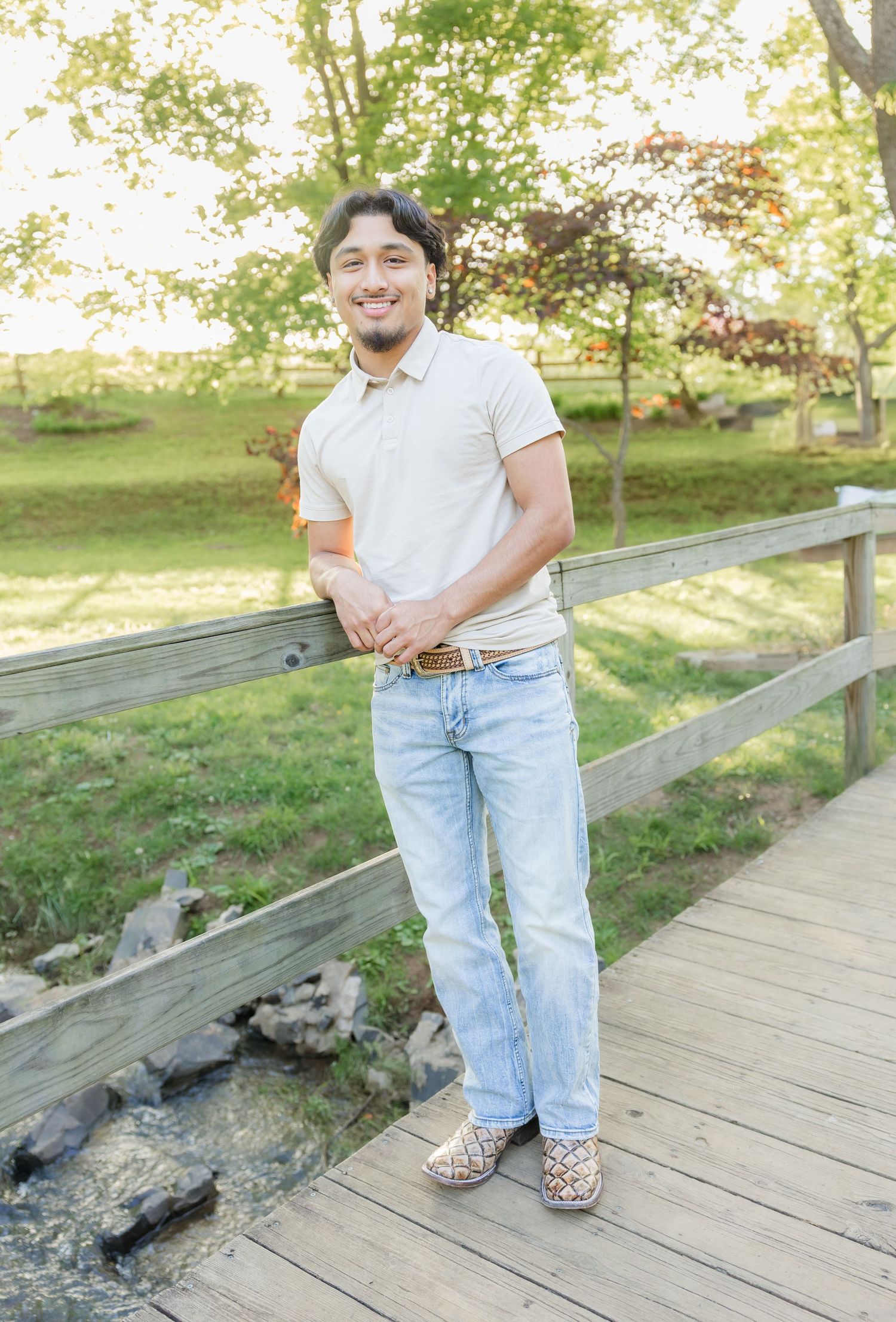 Person wearing casual attire standing on a wooden boardwalk in a natural setting.