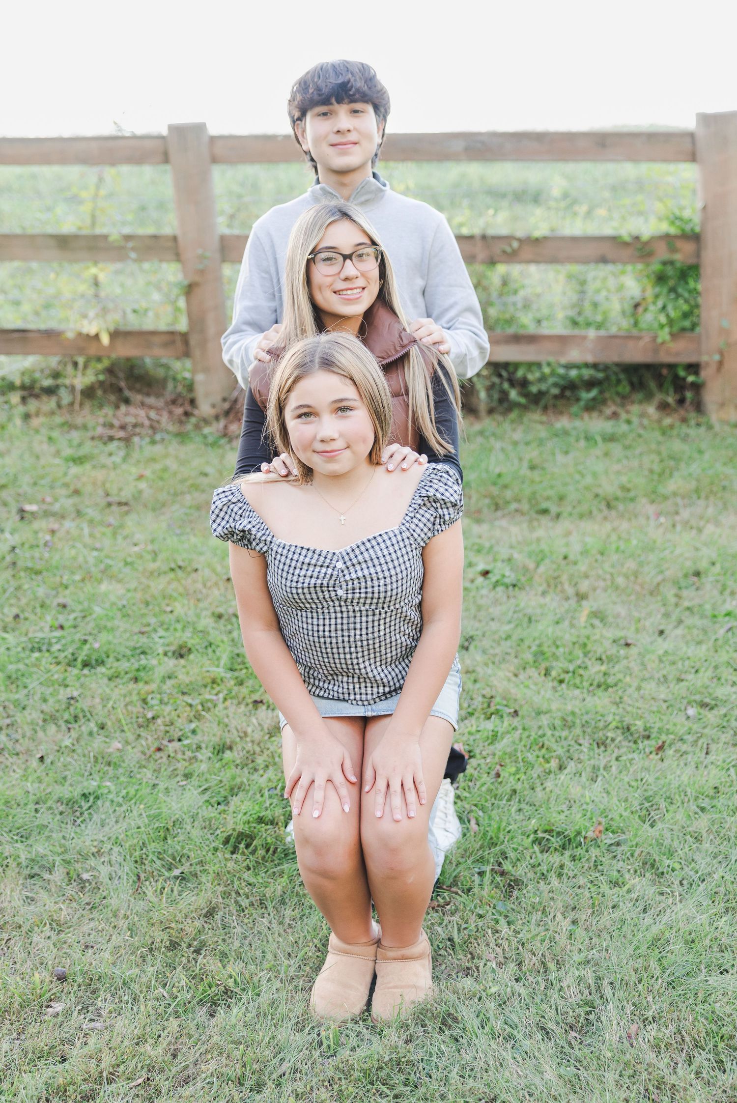 Casual outdoor portrait session showing playful poses in a gingham top on grassy lawn.