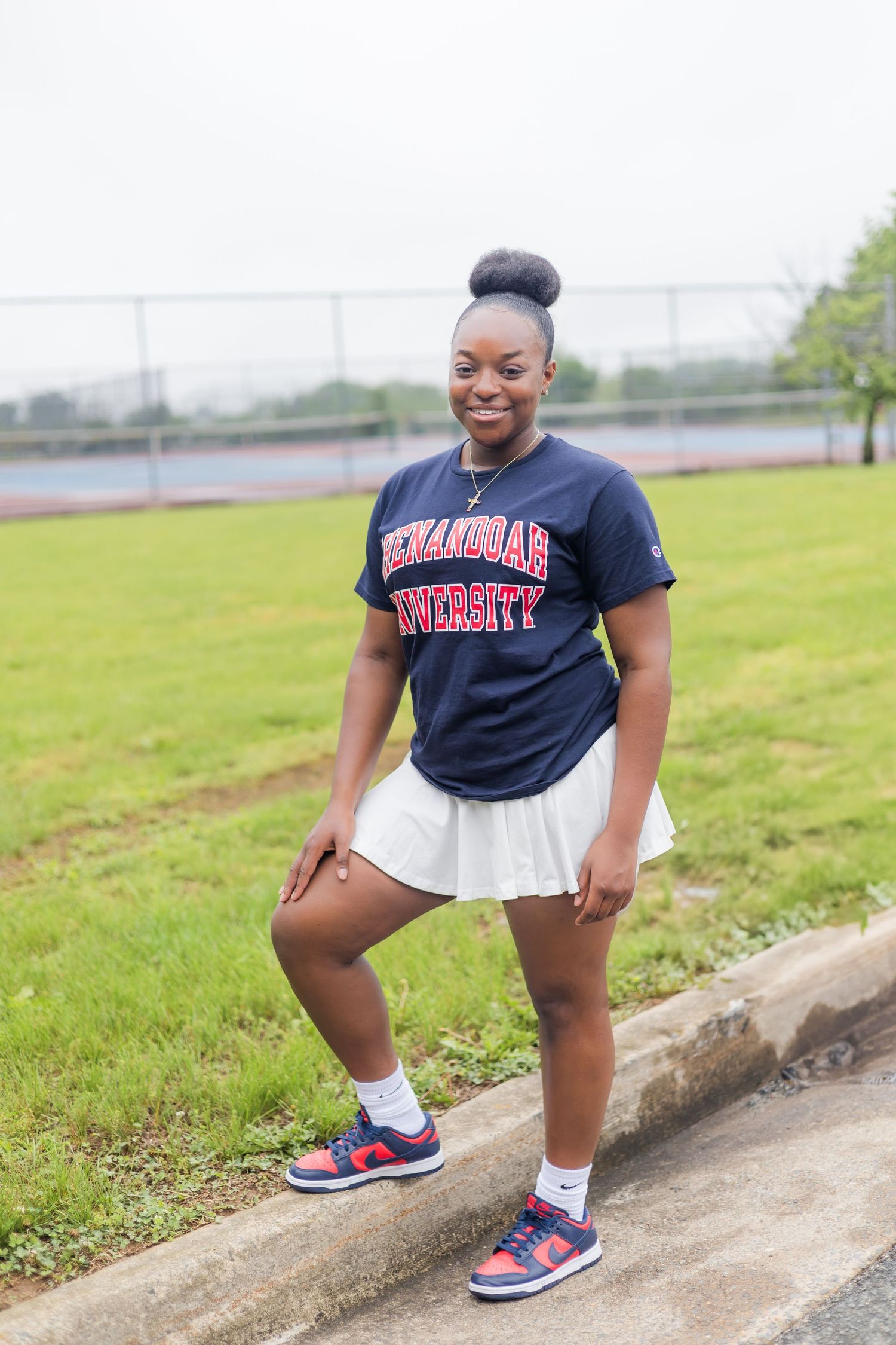 A person in athletic wear demonstrates dynamic poses on outdoor steps with red and blue sneakers.