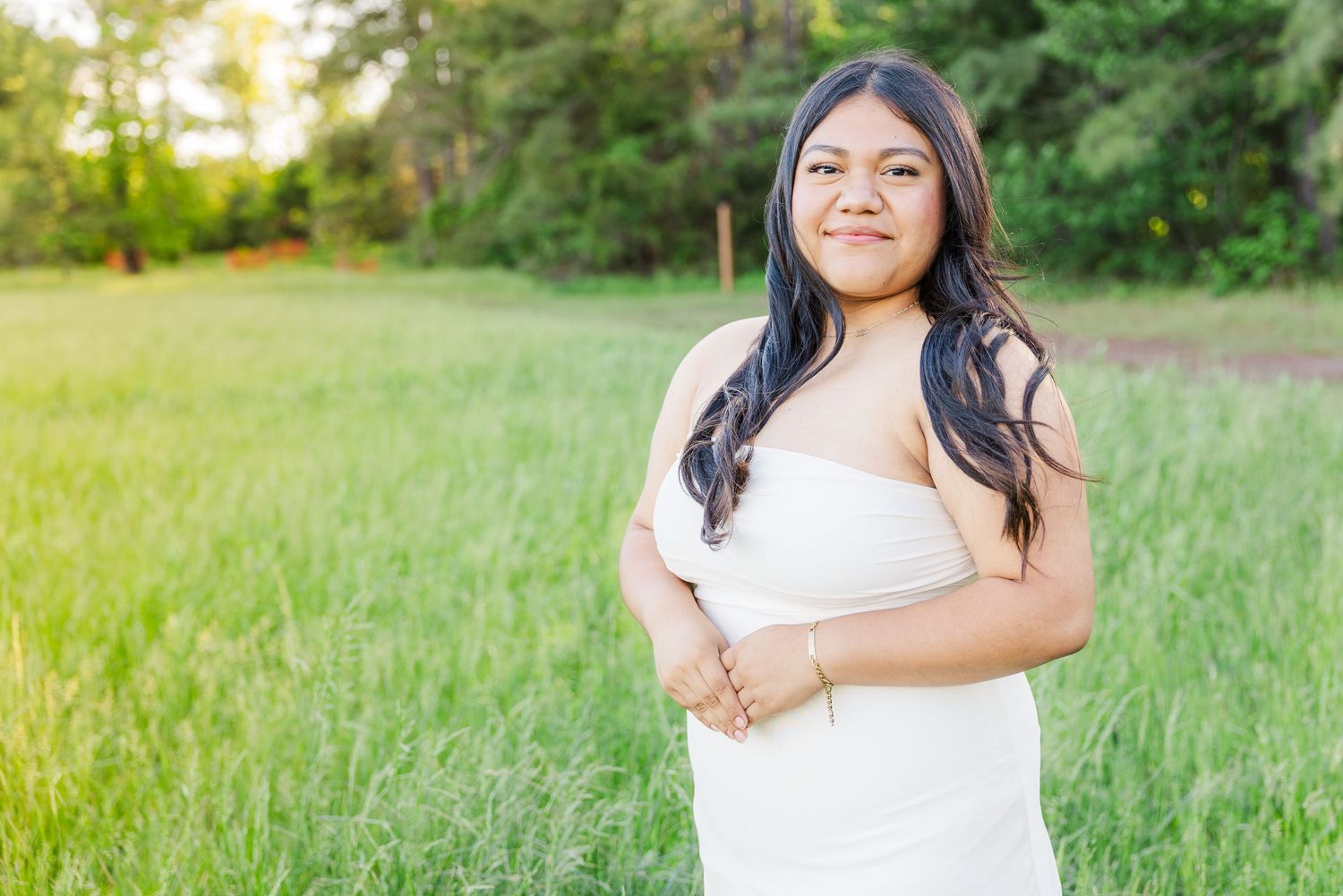 Casual outdoor portrait session in a sunlit grassy field.