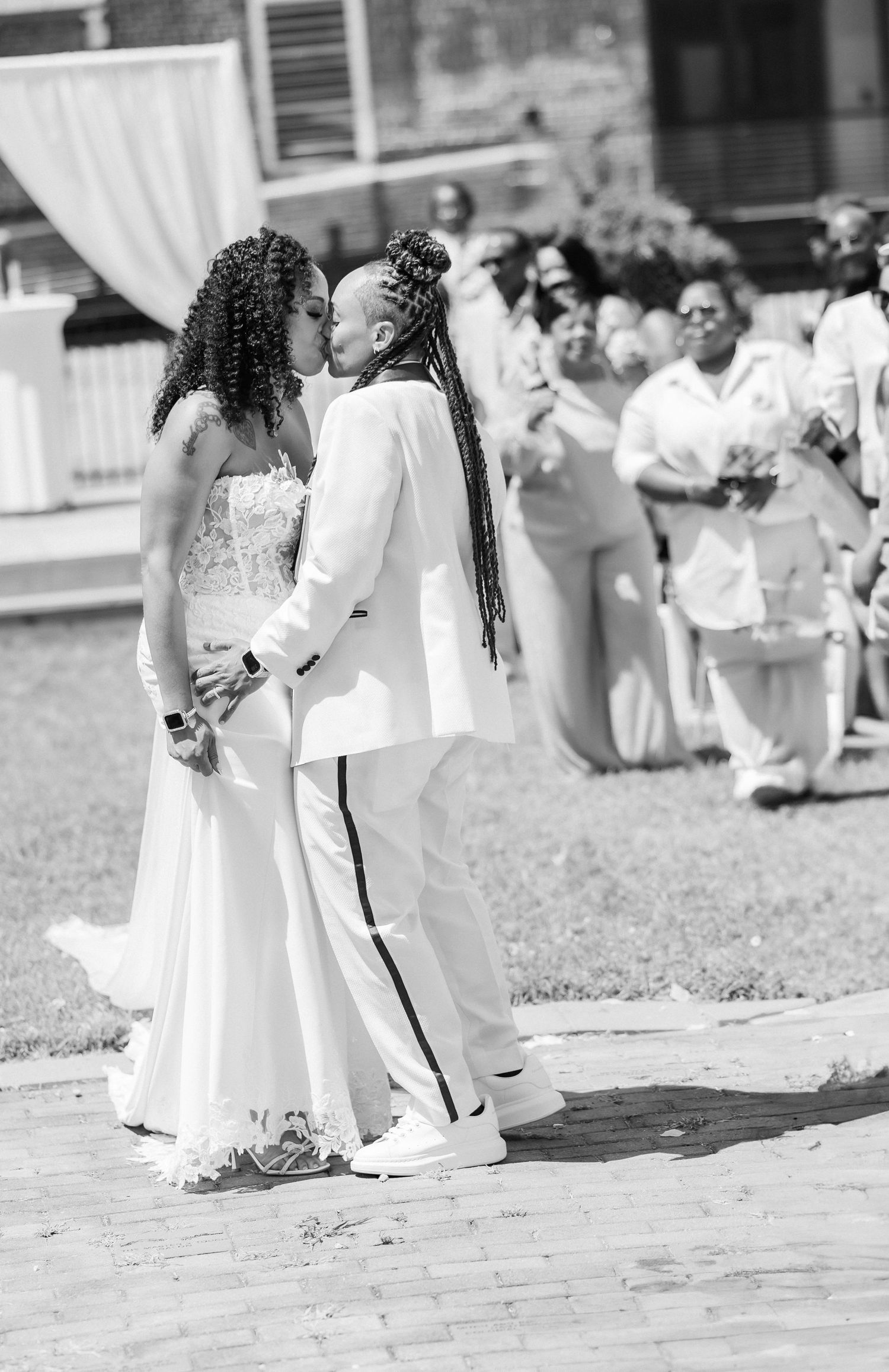 Black and white wedding photography showing ceremony moments on a brick patio.