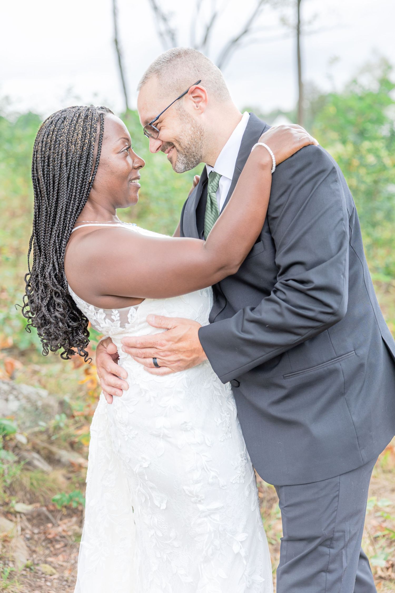 Wedding couple embraces lovingly during outdoor portrait session.