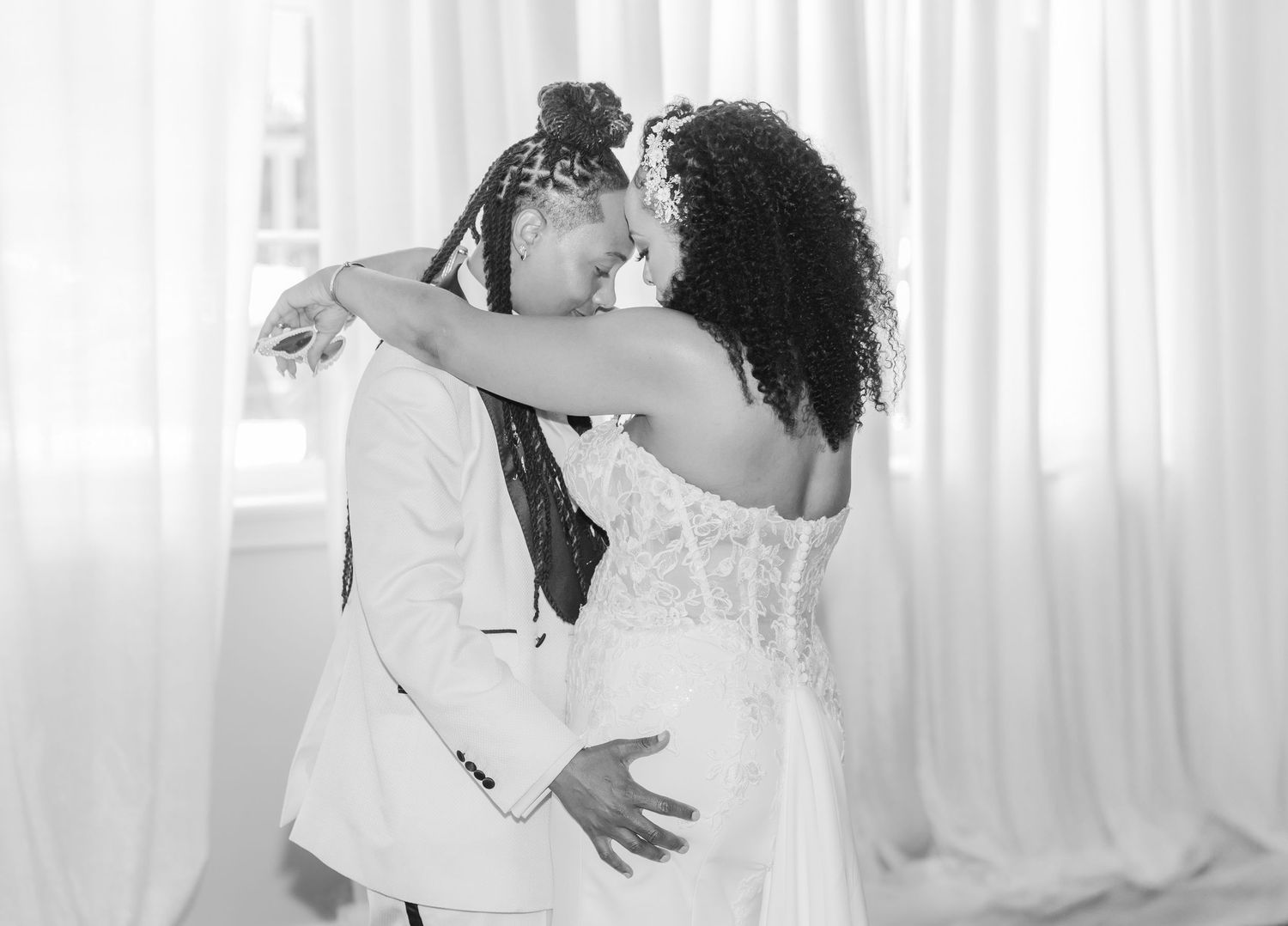 Romantic wedding ceremony moments captured in soft white lighting and drapery.
