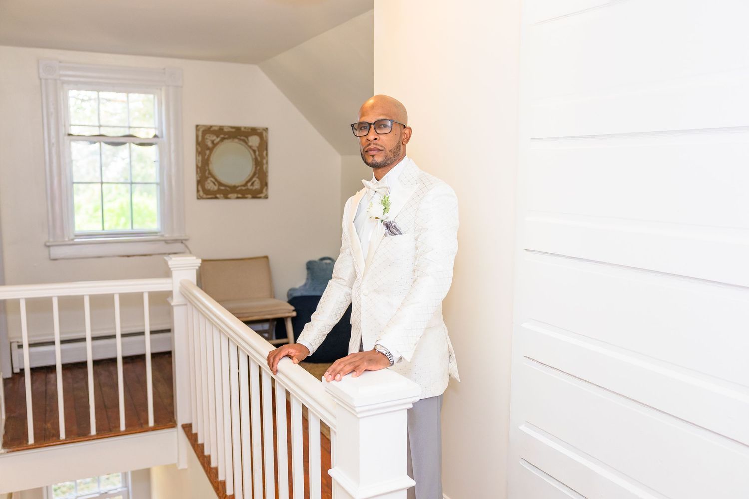 Professional painter in white coveralls carefully applies fresh paint to interior walls and trim of bright residential space.