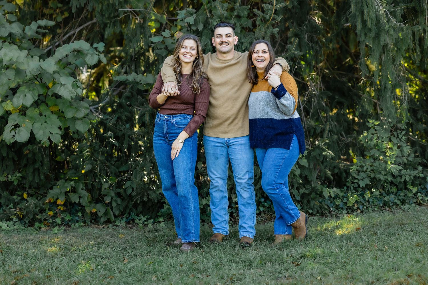 Family group in coordinated blue and earth tones posing outdoors.