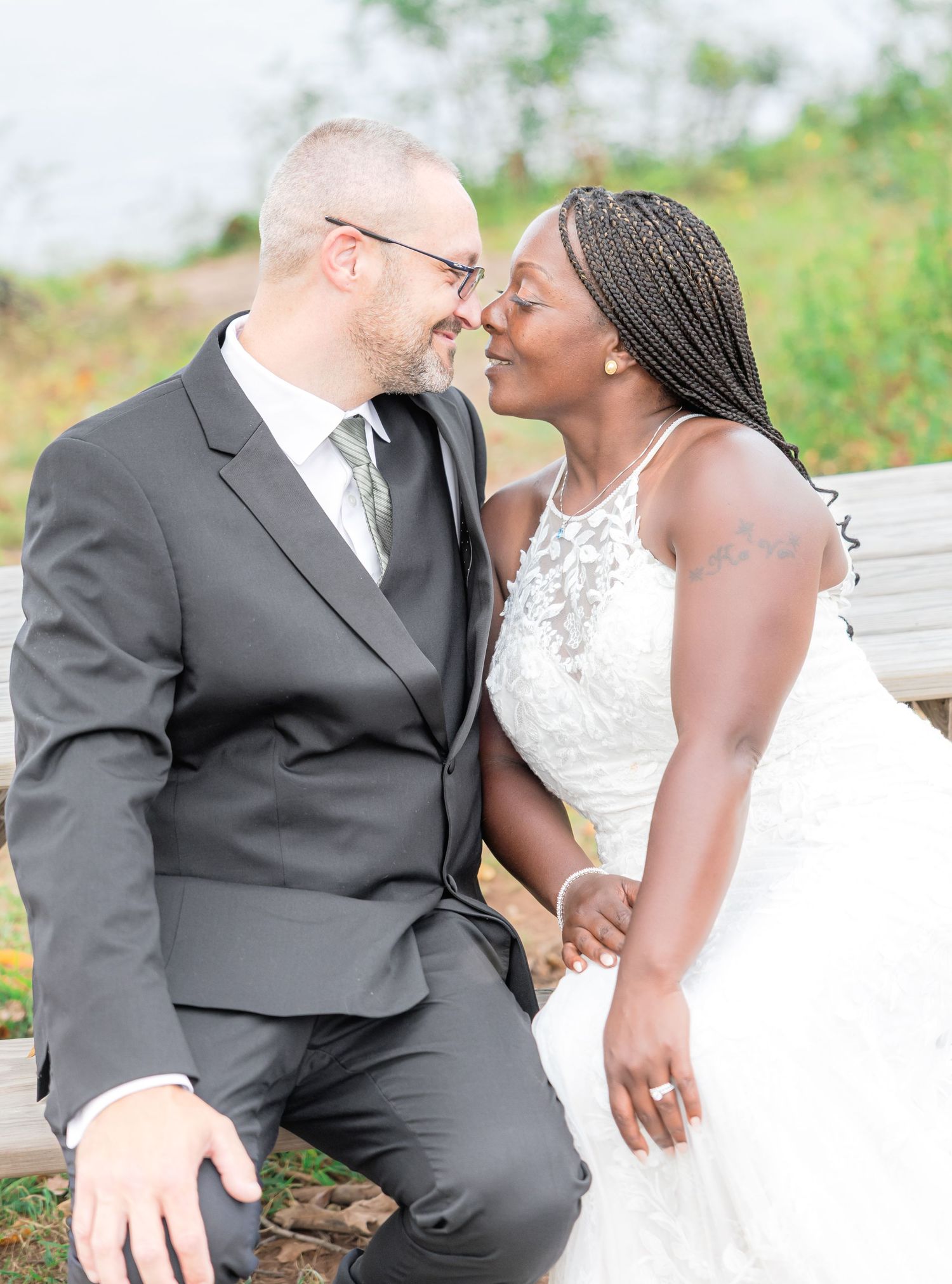 Newlyweds share intimate moment during outdoor wedding photoshoot.
