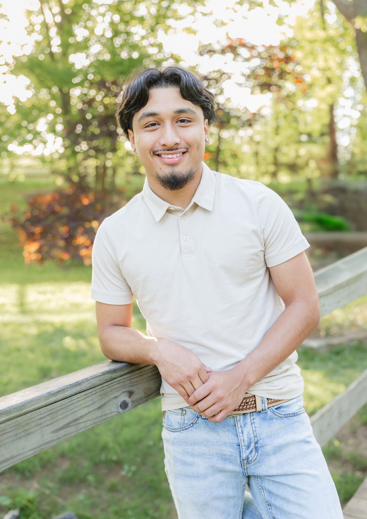 Person in white polo and jeans posing casually outdoors.