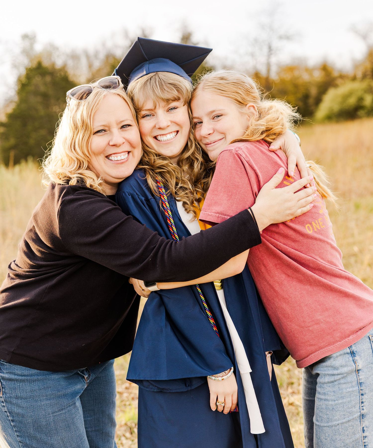 Joyful graduation celebration with family embracing outdoors.