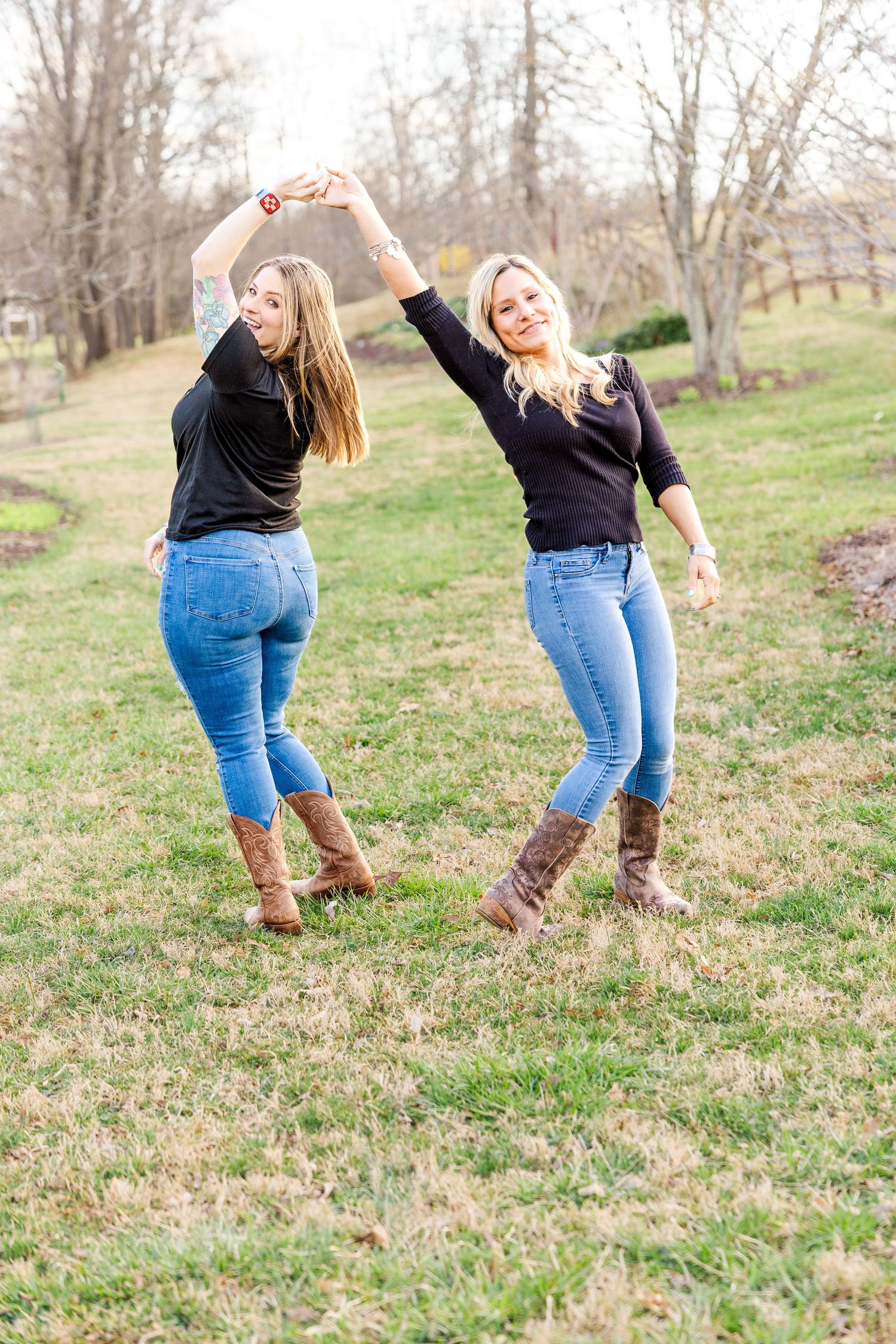 Friends dancing and holding hands while enjoying a moment outdoors.