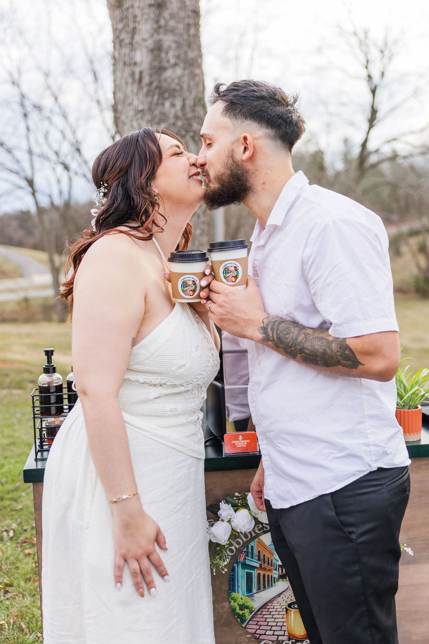 A romantic couple shares an intimate kiss in a garden setting with vintage lanterns and decorative elements.