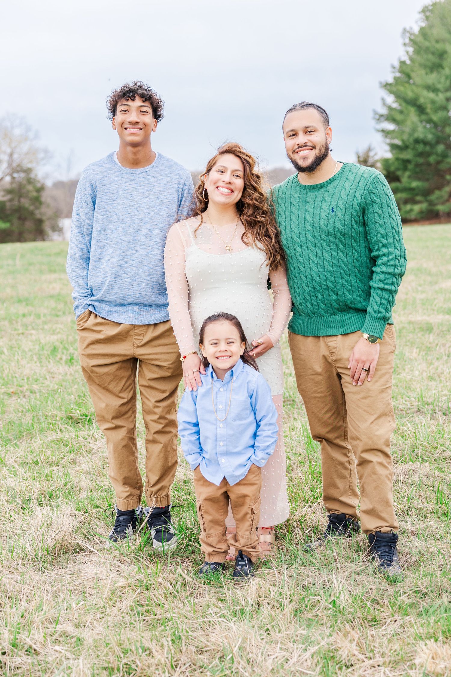 Family portrait session in a field with coordinating casual outfits.