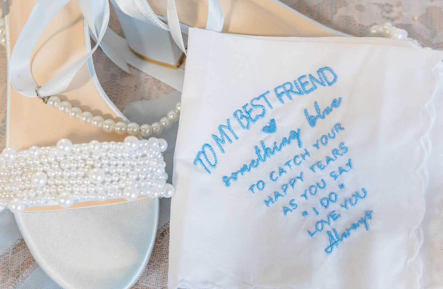 Handwritten note on white fabric with wedding accessories.