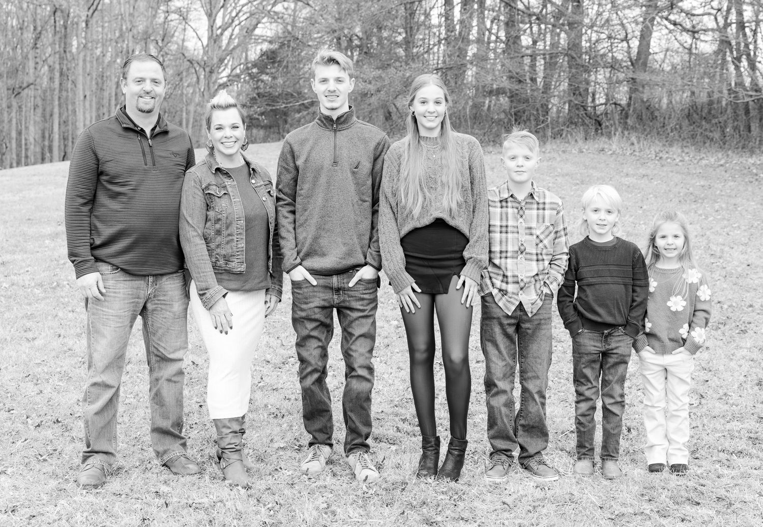 Black and white family portrait series showing different groupings of people standing together outdoors.