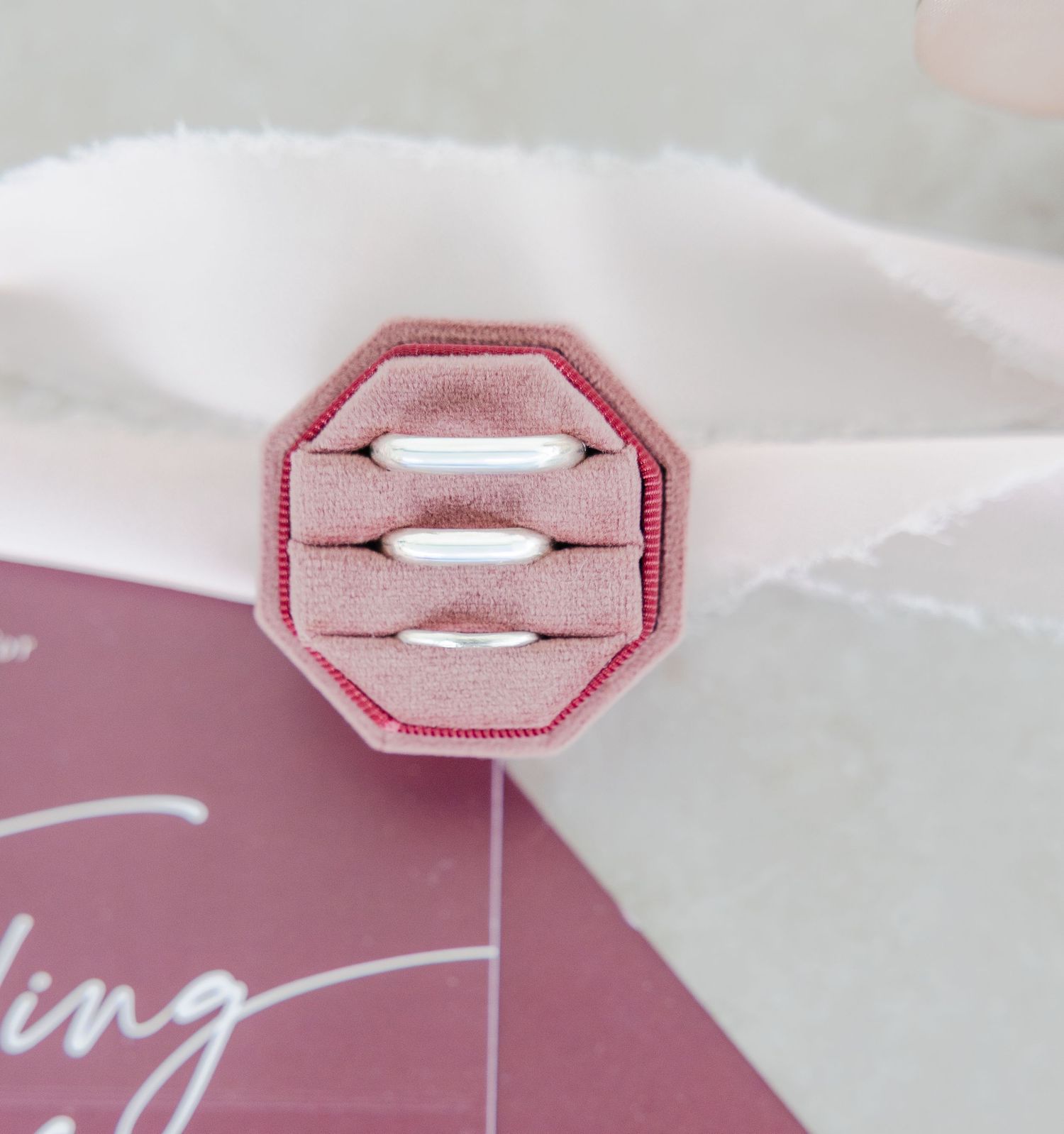 Close-up of geometric pink wax seal detail on wedding invitation.