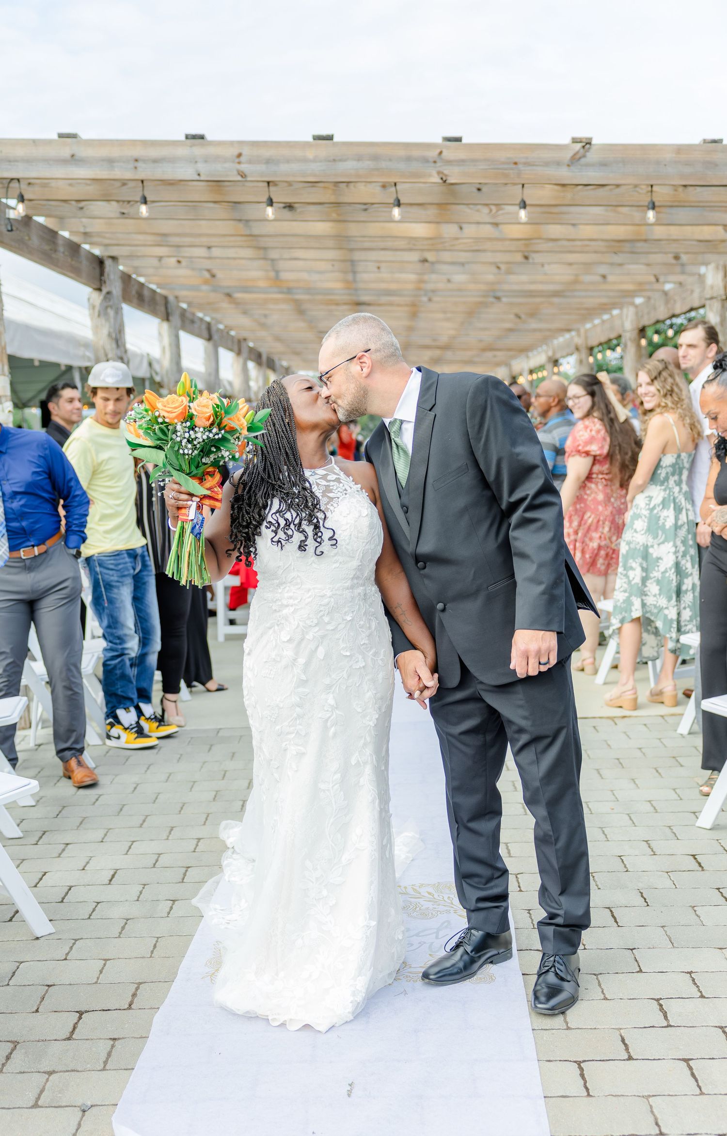 First dance moment at outdoor wedding reception under covered venue.