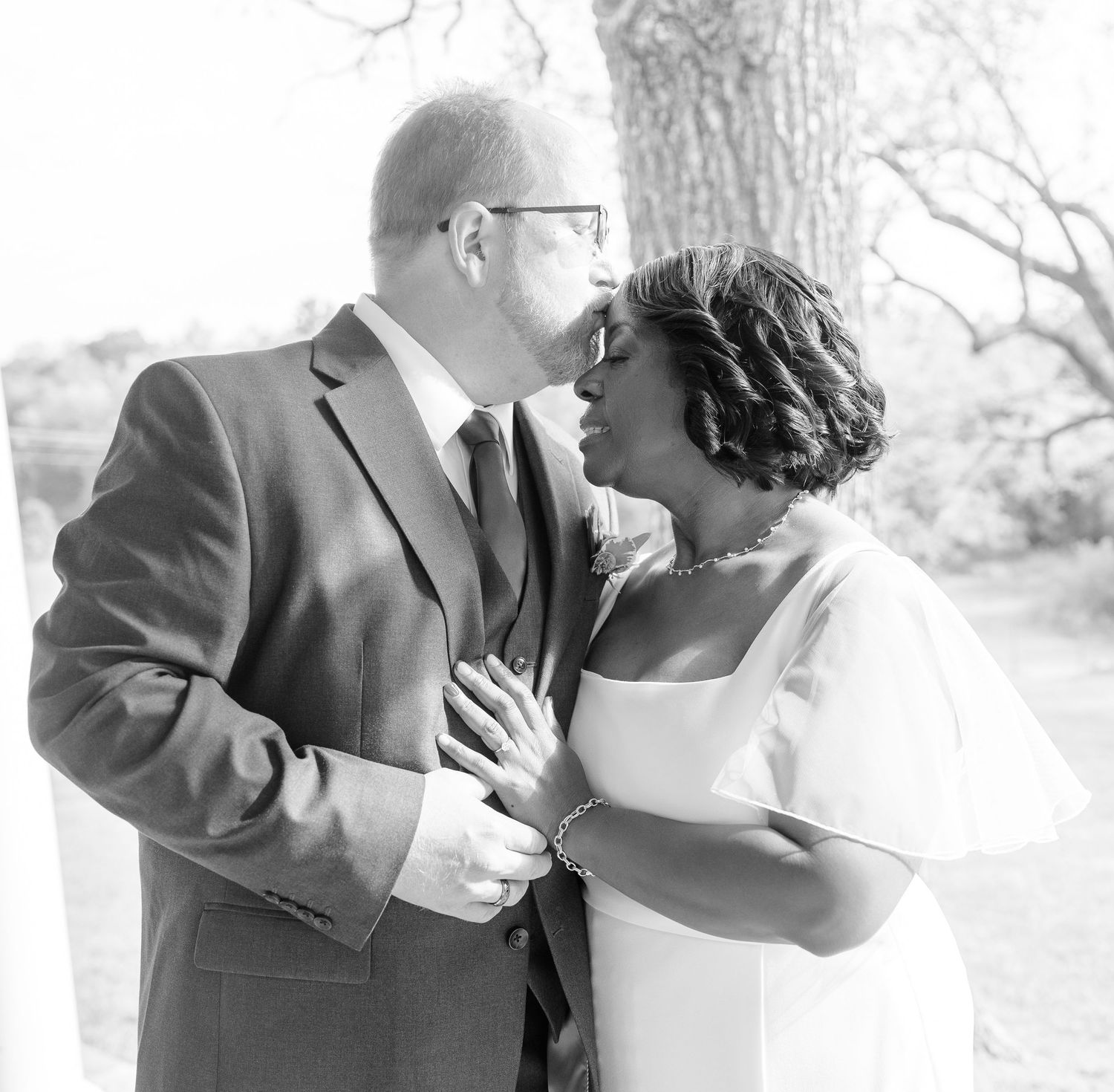 Black and white romantic portrait of couple in wedding attire.