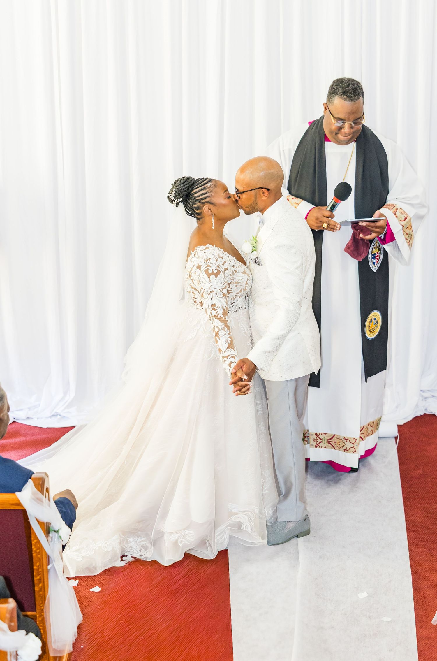 A wedding ceremony sequence showing a couple in white attire exchanging vows and sharing a special moment at the altar.