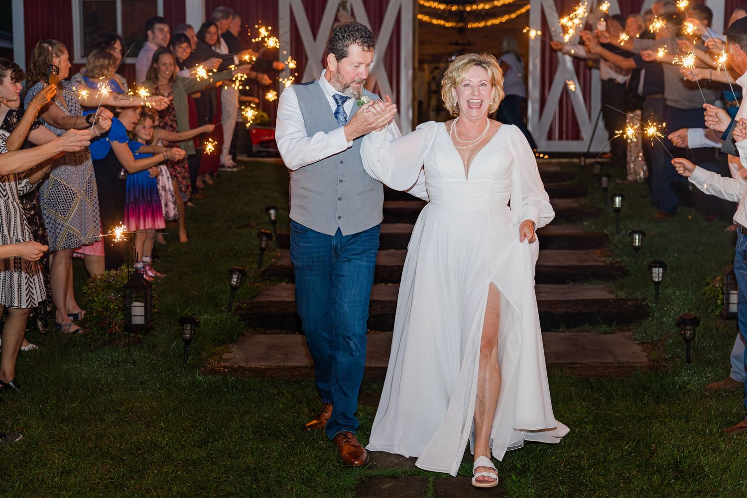 Wedding celebration at night with string lights creating romantic ambiance outdoors.