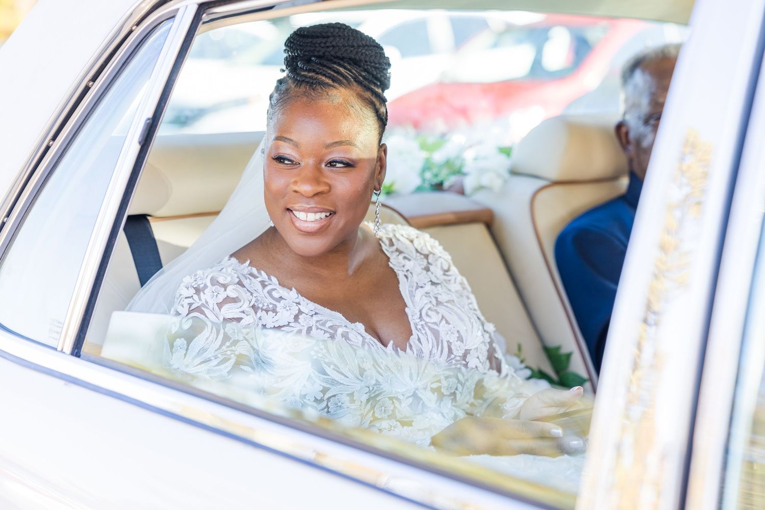 A wedding party rides together in a luxury vehicle decorated with white flowers and ribbons.