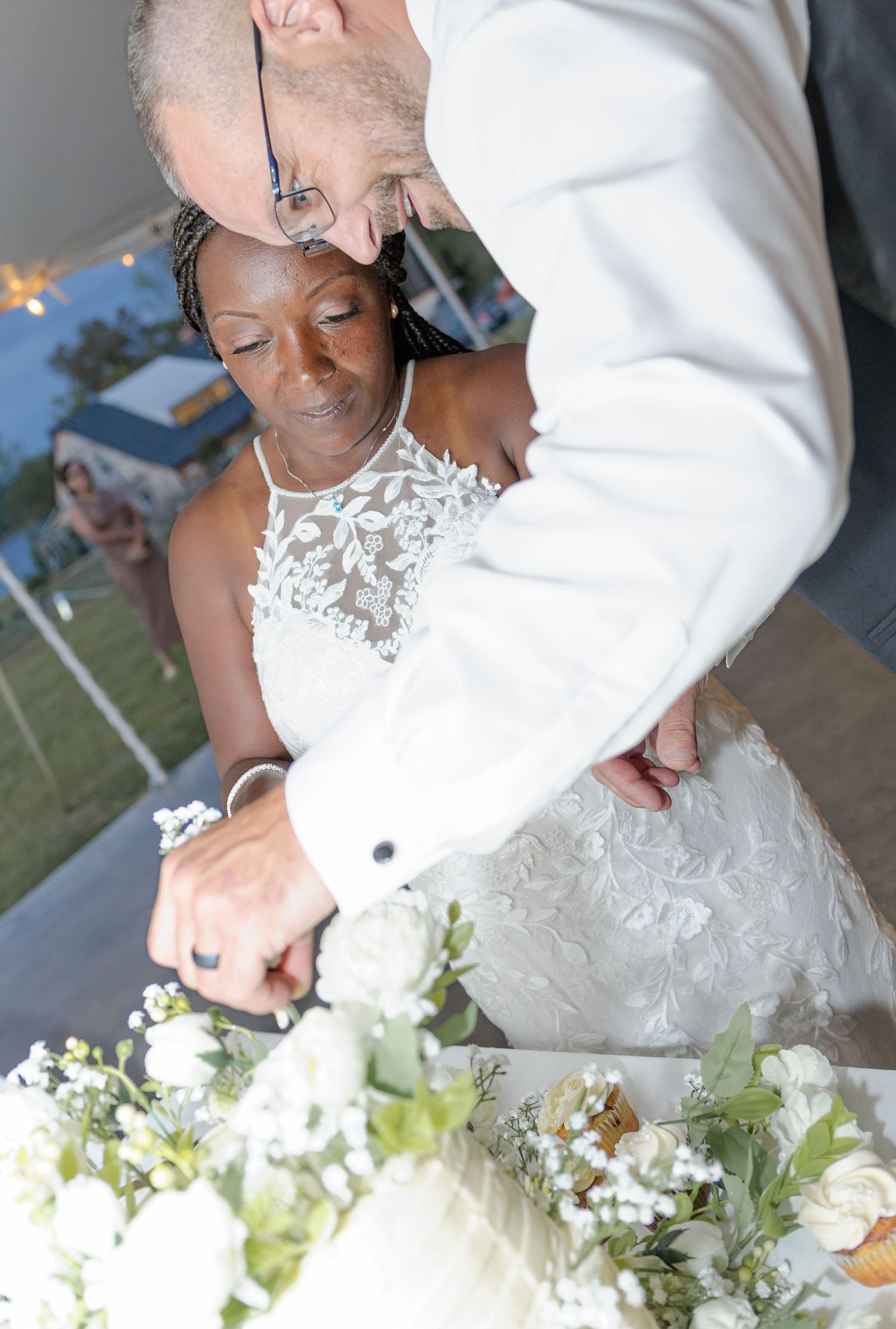Close-up of a white lace wedding dress with floral details.