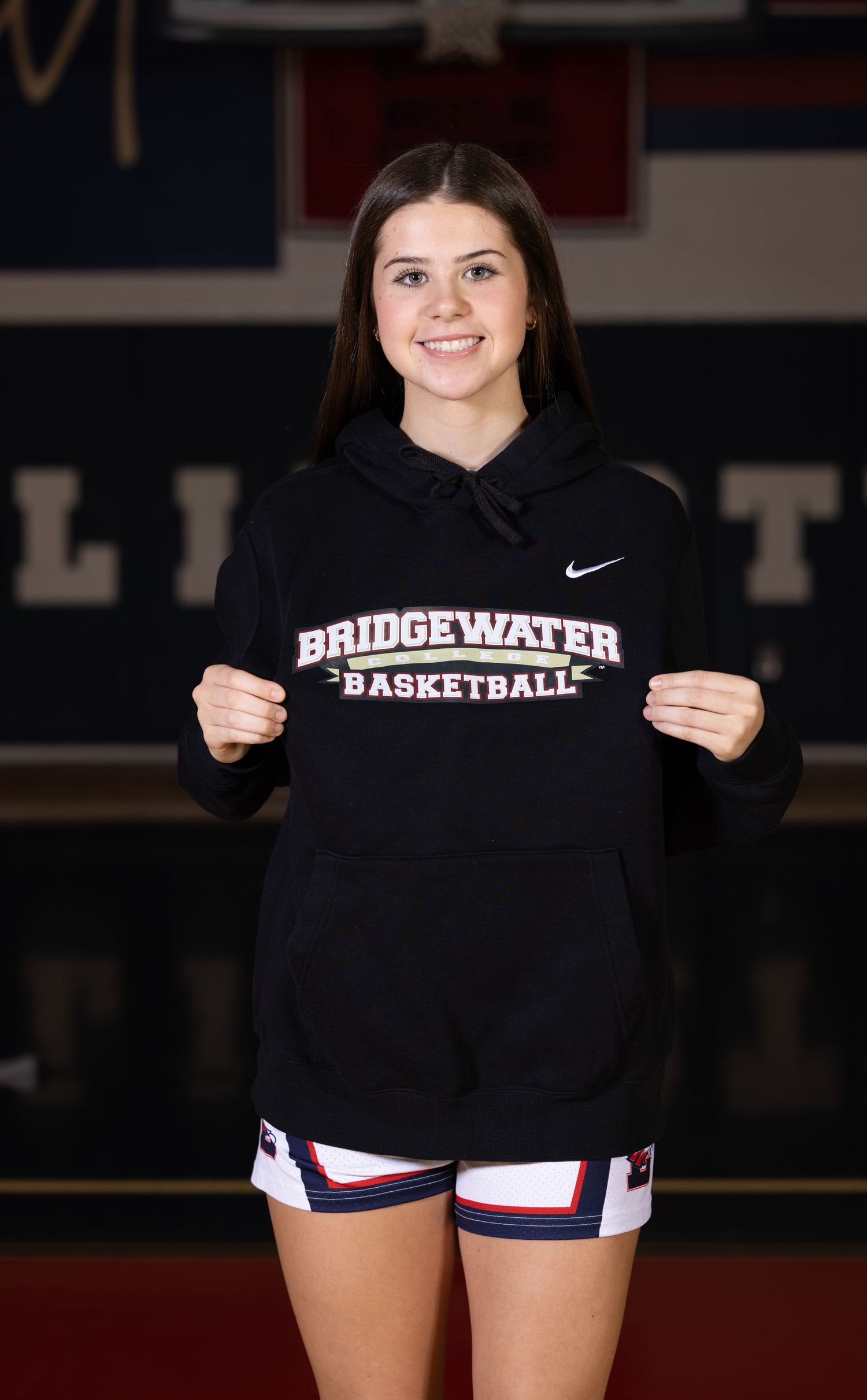Person displays Bridgewater Basketball sweatshirt in gym setting.