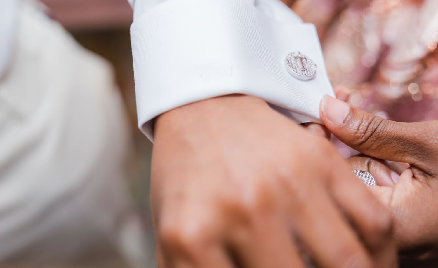 Close-up of hands holding small items during a formal event.