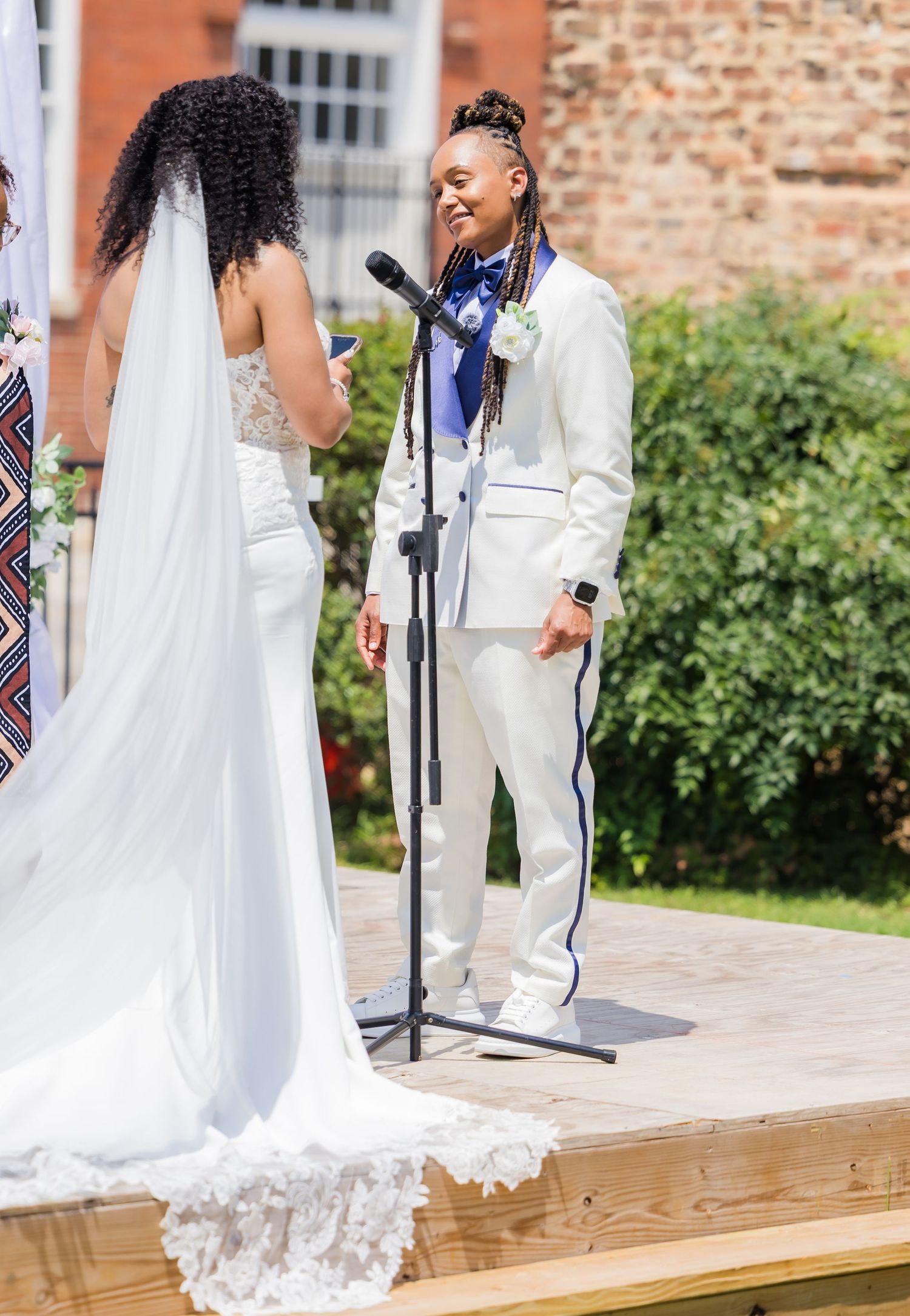 Wedding ceremony with couple at wooden altar under white draping.